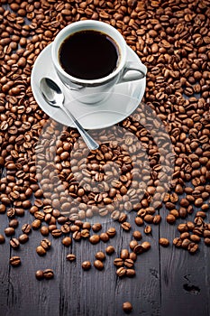 Cup with fragrant coffee drink on beans background