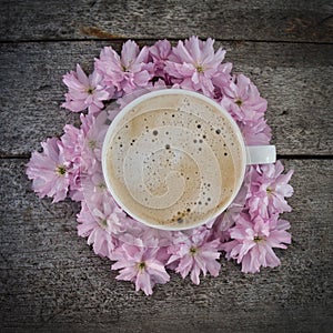 A cup of fresh coffee on a bunch of flowers