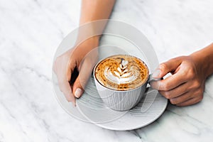 Cup of fresh coffee cappuccino in woman hands