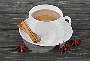 Cup of fresh hot coffee with spices on old rustic wooden table