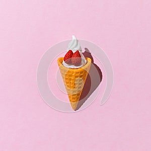 A cup of fresh ice cream with strawberries on a pink background