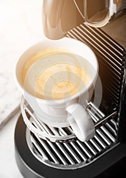 Cup of fresh morning coffee with espresso machine and sunlight on white background