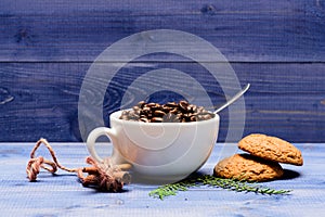 Cup full coffee brown roasted bean blue wooden background. Caffeine concept. Cafe drinks menu. Arabica robusta coffee