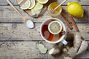 Cup of ginger tea with lemon and honey on wooden background. Top view. Antiviral useful Healthy drink