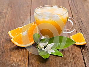 Cup of glass of orange juice with flower of orange tree and sli