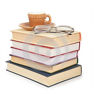 Cup and glasses on pile of book