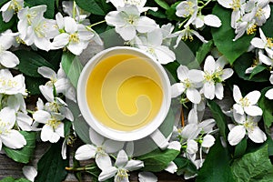 Cup of green jasmine tea on jasmine flowers background