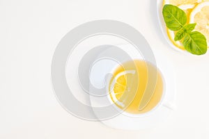 Cup of green tea with lemon, basil and mint shoot from above isolated on white background with copy space for text