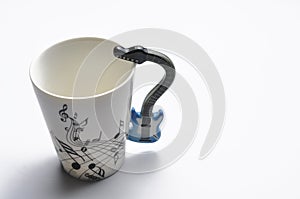 A cup with guitar handle. A cup for musician. Cup ispolated on white background.Copy space