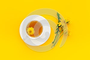 Cup of healing herbal tea with yellow dandelions flowers