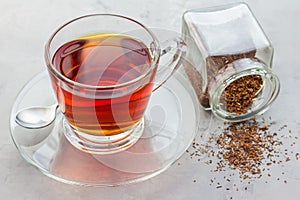 Cup of healthy herbal rooibos red tea in glass cup