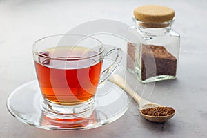 Cup of healthy herbal rooibos red tea in glass cup