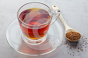 Cup of healthy herbal rooibos red tea in glass cup photo