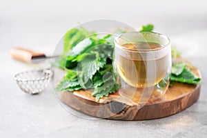 Cup of healthy herbal tea with nettle. Alternative herbal medicine. Stinging nettles, urtica. Skin allergy care. Fresh stinging