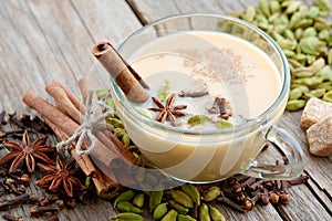 Cup of healthy masala tea with milk and aromatic spices and herbs. Ayurveda treatments. photo