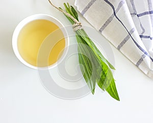 A cup of herbal tea against cough with fresh ribwort plantain leaves.Hebal medicine. Minimalism. Beautiful spring photo