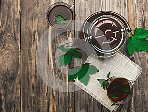 Cup with herbal tea on a background of fragrant green leaves and natural materials