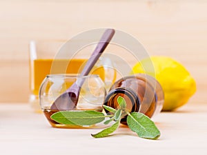 Cup of herbal tea with fresh sage ,honey and lemon on wooden ba