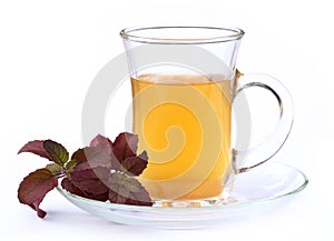 Cup of herbal tea with red tulsi leaves