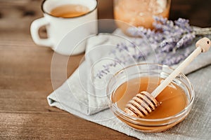 Cup of herbal tea with sage and honey with spoon in glass bowl o