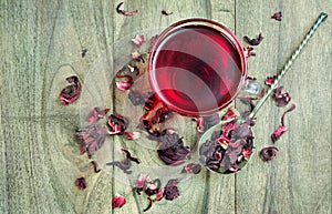 A cup of hibiscus tea on a wooden table. top view