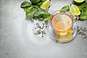 Cup with hot aromatic mint tea, lime, fresh