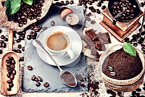 Cup of hot black coffee in setting with roasted coffee beans