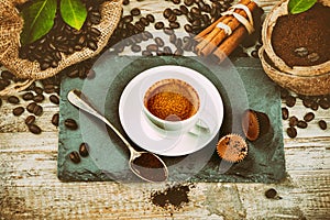 Cup of hot black coffee in setting with roasted coffee beans and