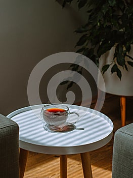 Cup of hot, black coffee with steam coming out of it on the table