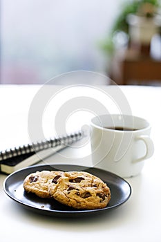 Cup of hot black coffee on white table background with notebook and stationery.  Work from home concept