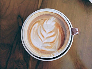 cup of hot cappucino on wodden table