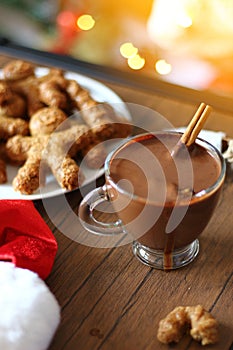 Cup of hot chocolate with cinnamon and christmas cookies.