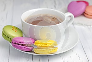 A cup of hot chocolate with colorful macarons