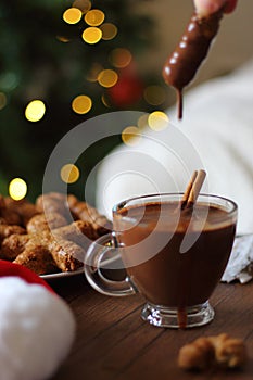 Cup of hot chocolate with gingerbread on wooden table.