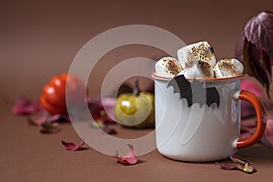 Cup of hot chocolate with marshmallow. Tasty Halloween food. Concept of cozy winter home environment. Autumn background.