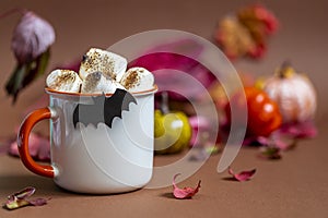 Cup of hot chocolate with marshmallow. Tasty Halloween food. Concept of cozy winter home environment. Autumn background.