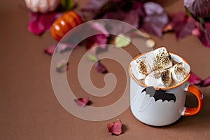 Cup of hot chocolate with marshmallow. Tasty Halloween food. Concept of cozy winter home environment. Autumn background.