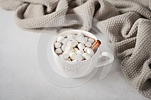 Cup of hot chocolate with marshmallows on a grey concrete background.