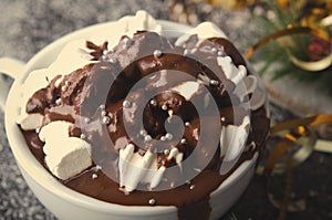 Cup of hot chocolate with marshmallows on snowy table, Christmas, New Year, Winter background