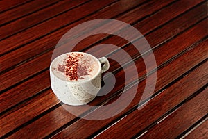 Cup of hot chocolate with milk foam and cocoa.