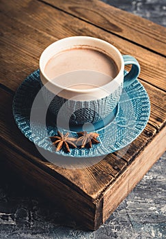 Cup of hot chocolate in winter decorations on the rustic background