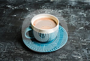 Cup of hot chocolate in winter decorations on the rustic background