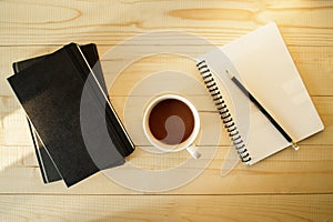 Cup of hot chocolate on wooden background with notebook.  Work from home concept