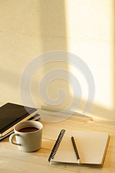 Cup of hot chocolate on wooden background with notebook.  Work from home concept