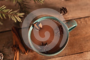 Cup of hot cocoa or hot chocolate on knitted background with fir tree and snow effect, traditional beverage for winter time