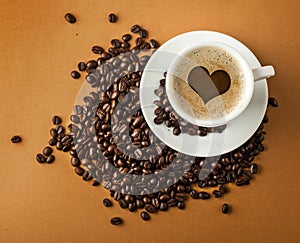 Cup of hot coffee with beans on paper background