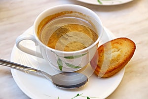 Cup of Hot Coffee with a Financier French Almond Mini Cake on White Table