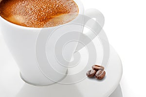 A cup of hot coffee with foam on a white background