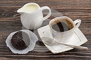 Cup of hot coffee, jug milk and chocolate cake