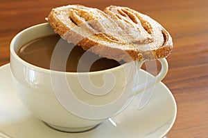 Cup of hot coffee and palmier cookie